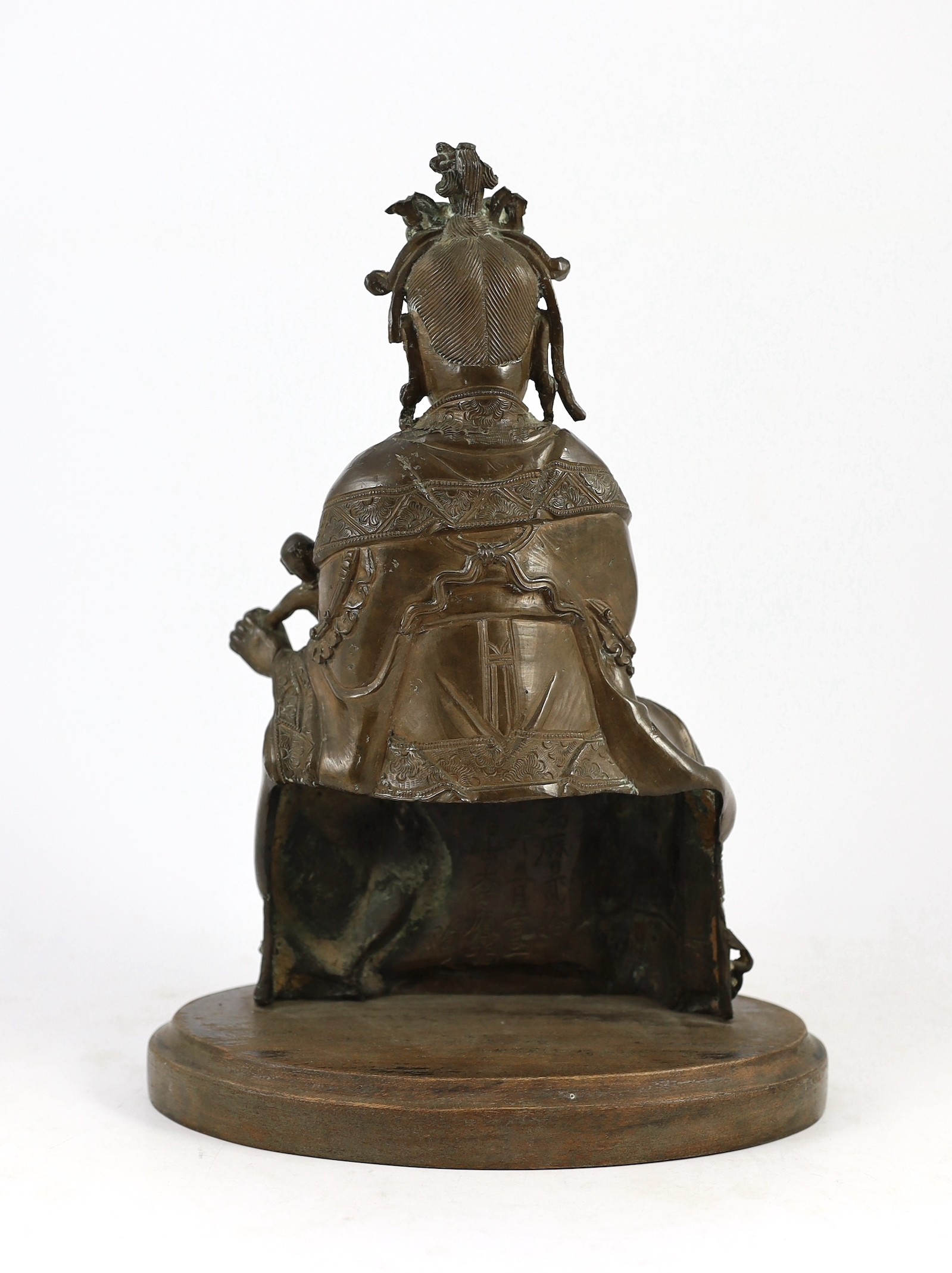 A large Chinese bronze group of Xi Wangmu and a child, late Ming dynasty, 31.5cm high excluding later wood stand